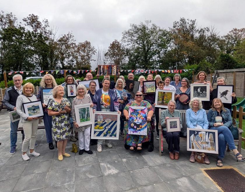 Group photo of artists holding their works