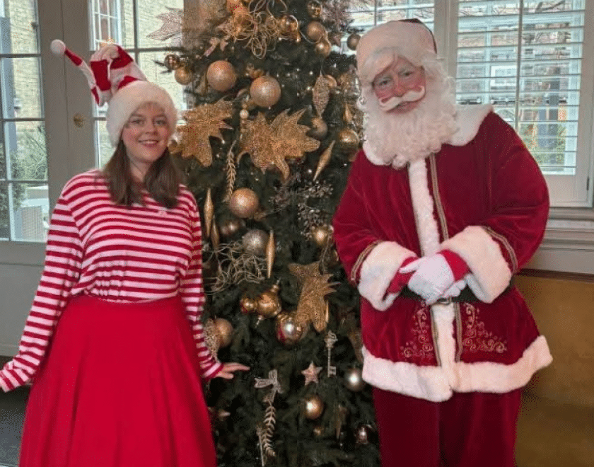 Santa and his Elf beside a Christmas tree